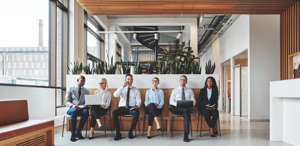 Diverse and smiling business people working in the reception area of an office